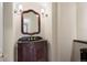 Elegant powder room with a dark wood vanity, ornate mirror, and decorative sconces at 4800 E Cedar Ave, Denver, CO 80246