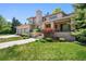 Stunning two-story home featuring a manicured lawn, a three-car garage, and a covered porch entrance at 4800 E Cedar Ave, Denver, CO 80246