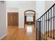 Elegant foyer with hardwood floors, staircase, and view of a study with built-in shelves at 4800 E Cedar Ave, Denver, CO 80246