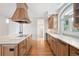 Modern kitchen with large island, custom range hood, and bright countertops at 4800 E Cedar Ave, Denver, CO 80246