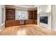 Bright living room featuring custom built-in bookcases, a fireplace, and gleaming hardwood floors at 4800 E Cedar Ave, Denver, CO 80246