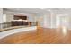 Open living room with hardwood floors, railing, built in shelves, and a wet bar in the background at 4800 E Cedar Ave, Denver, CO 80246