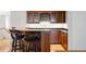 Wet bar with wood cabinets, counter seating, and lots of storage and light at 4800 E Cedar Ave, Denver, CO 80246