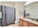 Clean bathroom with granite counter and shower with grey shower curtain at 4100 Albion St # 611, Denver, CO 80216