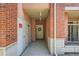 A covered building entrance framed with brick walls and a door to a condo unit at 4100 Albion St # 611, Denver, CO 80216