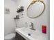 Stylish powder room featuring a white sink, dark vanity, and gold-framed mirror at 1061 S Yampa St # C, Aurora, CO 80017