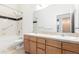 Bathroom featuring a double sink vanity, a large mirror and tiled shower with grab bars at 7700 E 29Th Ave # 405, Denver, CO 80238