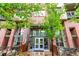 Beautiful entrance to The Lofts at Central Park with modern glass doors, brick facade, and greenery at 7700 E 29Th Ave # 405, Denver, CO 80238