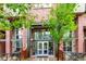 Inviting entrance of The Lofts at Central Park, showcasing brick facade and modern glass doors at 7700 E 29Th Ave # 405, Denver, CO 80238