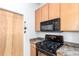 Kitchen featuring granite counters, wood cabinets, and a black appliance package at 7700 E 29Th Ave # 405, Denver, CO 80238