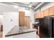 A kitchen with granite counters, wood cabinets, and a black appliance package at 7700 E 29Th Ave # 405, Denver, CO 80238