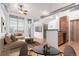 Bright living area featuring a comfortable beige sectional, wood floors, and an open layout with a partial kitchen view at 7700 E 29Th Ave # 405, Denver, CO 80238