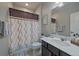 Bathroom features a shower-tub combo with a shower curtain, a vanity with sink, and decorative mirror at 11926 Olive St, Thornton, CO 80233