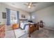 A cozy bedroom with wood furniture, light gray walls, a ceiling fan and colorful accessories at 11926 Olive St, Thornton, CO 80233