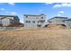 The back exterior view of three modern homes featuring gray siding and wooden fences, creating a cozy community feel at 11926 Olive St, Thornton, CO 80233