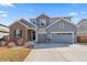 Beautiful two-story home with a mix of brick and siding, a well-manicured lawn, and a two-car garage at 11926 Olive St, Thornton, CO 80233