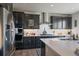 Kitchen with stainless steel appliances, gas cooktop, white subway tile backsplash, and dark wood cabinets at 11926 Olive St, Thornton, CO 80233