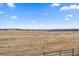 Scenic view of an expansive field from the property with clear blue sky and scattered clouds at 11926 Olive St, Thornton, CO 80233