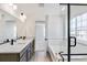 Modern bathroom featuring double sink, wood-look tile floors, and glass-enclosed shower and tub at 4451 Soapberry Pl, Castle Rock, CO 80108