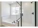 Modern bathroom featuring subway tile shower, separate soaking tub, and a bright window at 4451 Soapberry Pl, Castle Rock, CO 80108