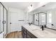Modern bathroom featuring double sink, wood-look tile floors, and glass-enclosed shower at 4451 Soapberry Pl, Castle Rock, CO 80108