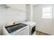 Convenient laundry room features modern washer and dryer, plus storage shelf at 4451 Soapberry Pl, Castle Rock, CO 80108