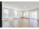Bright, open living room featuring hardwood floors, large windows, and a modern light fixture at 4451 Soapberry Pl, Castle Rock, CO 80108