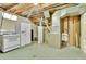 Unfinished basement with appliances, water heater, and open ceilings at 7101 Alan Dr, Denver, CO 80221