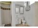 Functional bathroom features a white vanity, toilet and shower with patterned tile accents at 7101 Alan Dr, Denver, CO 80221