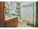 A well lit bathroom with storage, shelving and shower at 7101 Alan Dr, Denver, CO 80221