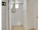All white bathroom with a tiled shower and a window with a floral curtain at 7101 Alan Dr, Denver, CO 80221