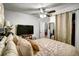 Comfortable bedroom with ceiling fan, TV, and window with curtains at 7101 Alan Dr, Denver, CO 80221