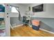 A childs bedroom with a gray accent wall, a desk, an air conditioner and wood floors at 7101 Alan Dr, Denver, CO 80221