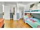 bedroom with a bunk bed, gray accent wall, and wood floors at 7101 Alan Dr, Denver, CO 80221