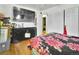 A bedroom with a dark dresser, a large flatscreen television and a floral-patterned bedspread at 7101 Alan Dr, Denver, CO 80221