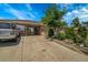 Exterior view of a home featuring a long driveway, covered carport, and beautiful landscaping at 7101 Alan Dr, Denver, CO 80221
