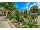 Landscaped front yard featuring lush greenery, colorful flowers, and neatly trimmed bushes adding curb appeal at 7101 Alan Dr, Denver, CO 80221