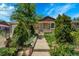 Charming single-story home featuring a well-maintained lawn, beautiful flower beds, and a welcoming front porch at 7101 Alan Dr, Denver, CO 80221