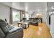 Living room filled with leather seating, wood floors, bright light, and dining area at 7101 Alan Dr, Denver, CO 80221