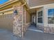 Charming entryway of home features brick accents and a well-lit porch at 15217 Xenia St, Thornton, CO 80602