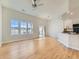 Open floor plan of living room and kitchen features hardwood floors and natural light at 15217 Xenia St, Thornton, CO 80602