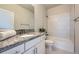 Clean bathroom with granite countertop, white cabinets, and a bathtub at 9880 E 160Th Pl, Brighton, CO 80602