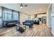 Open living room with gray sofas, hardwood floors, and a view into the kitchen at 9880 E 160Th Pl, Brighton, CO 80602