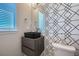 Stylish powder room with black vessel sink, geometric wallpaper, and modern fixtures at 9880 E 160Th Pl, Brighton, CO 80602