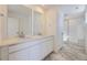 Bathroom with double sink vanity, quartz counters, and a glass enclosed shower at 8858 Waterleaf Ln, Littleton, CO 80125