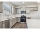 Well-equipped kitchen featuring stainless appliances, white subway tile backsplash, and gray cabinets at 1638 Plata St, Lochbuie, CO 80603