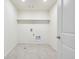 Practical laundry room with tile flooring, shelving, and washer/dryer connections at 1638 Plata St, Lochbuie, CO 80603