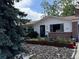 View of a white single Gathering house and a decorative front yard at 1843 S Urban Way, Lakewood, CO 80228