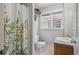 Bright bathroom showcasing a tiled shower, window, modern toilet and sink at 1580 N Franklin St, Denver, CO 80218