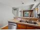 Well-lit kitchen featuring a stainless steel dishwasher and a double basin sink with tile counters at 1580 N Franklin St, Denver, CO 80218